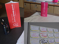 机の上にスタンプカードと赤い案内札が置かれた受付コーナーの写真