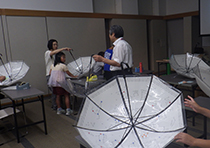 白い傘が開いた状態で机の上に置かれている様子の写真