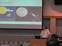 スクリーンの前に立つ一人の男性の全身の写真