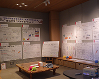 展示室内で机を囲んで掲示された調査発表パネルと資料が展示されている写真