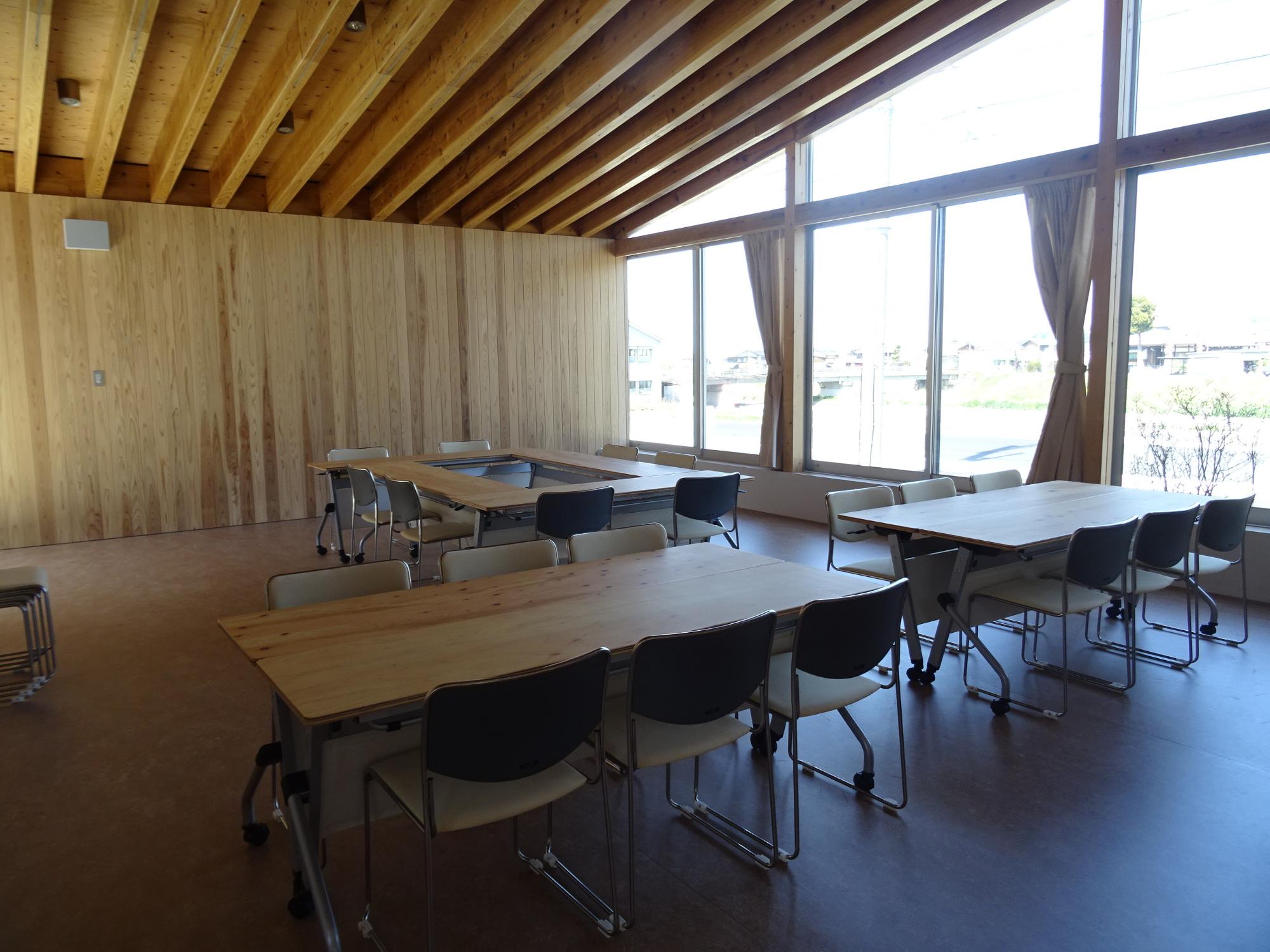 天井の梁が見える木造の明るい会議室内部の写真