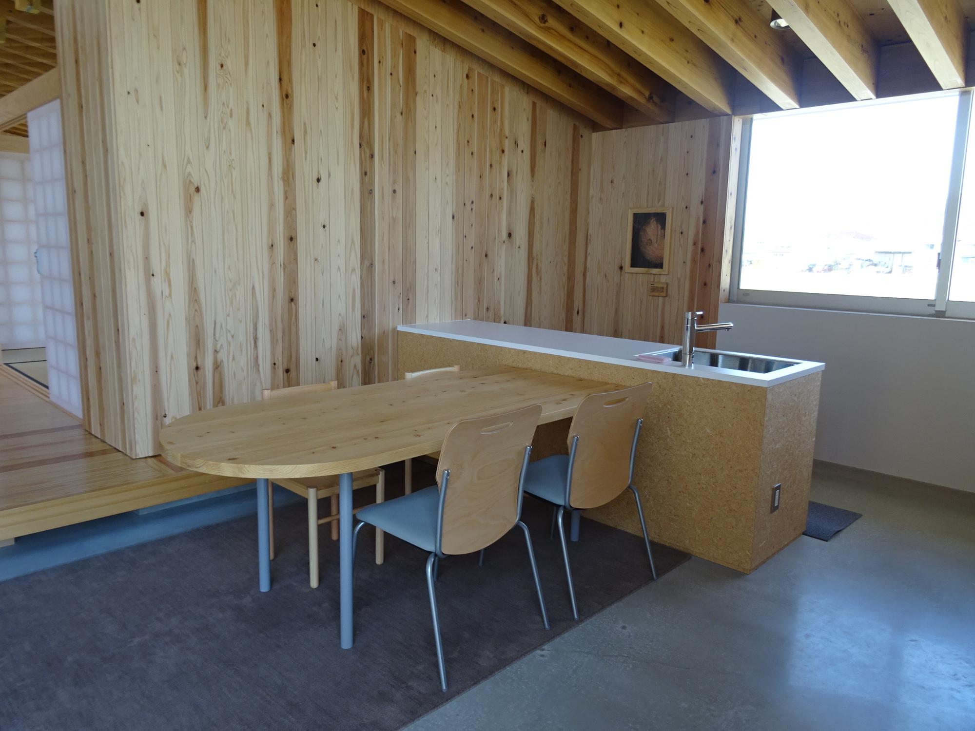 木製のテーブルと簡易キッチンが設けられたいこいの広場を斜めから写した写真