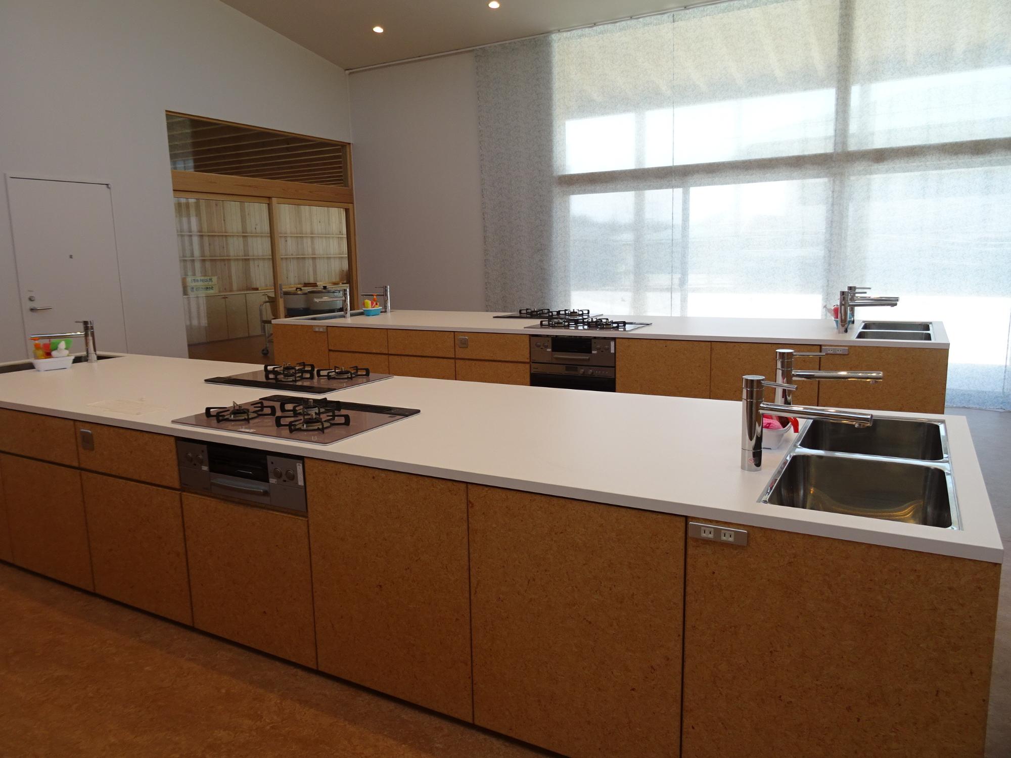 ガラス越しに調理台や設備が見える調理室の外観を横から写した写真