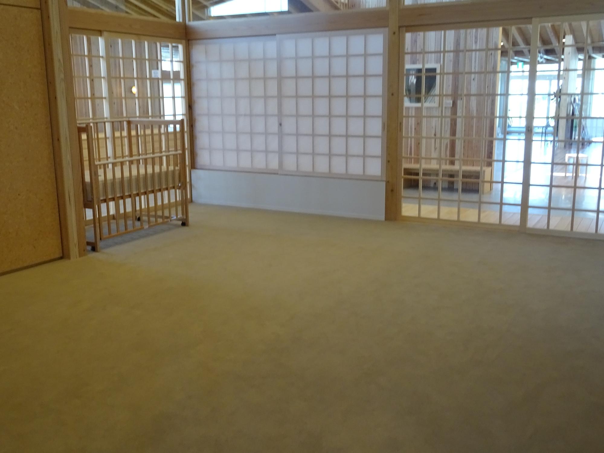 障子戸で仕切られたカーペットの託児・乳児室を正面から写した写真