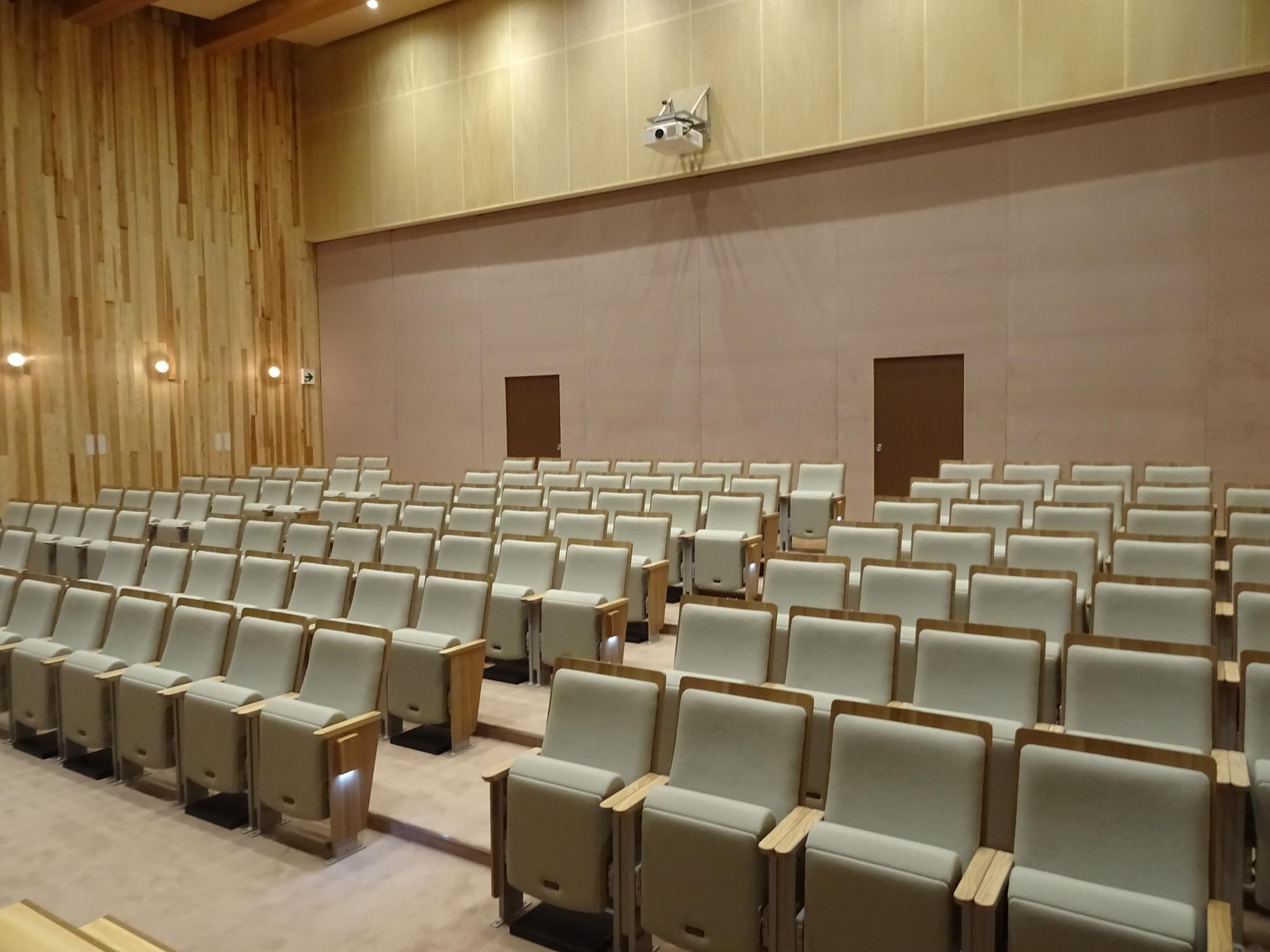 段差のある客席が整然と並ぶホール内を斜め前方から写した写真