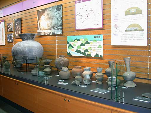 大小さまざまな大きさの壺状型の副葬品が展示されている様子の写真