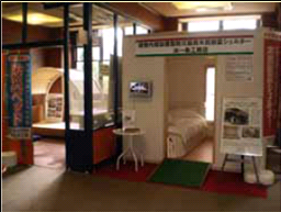 中にベッドが置かれた小さな個室が展示されている写真