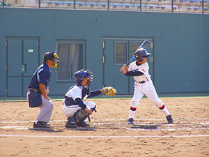 一番右手でバッターが構えていて、真ん中でキャッチャーが構えていて、一番左手に審判が腰を屈めている写真