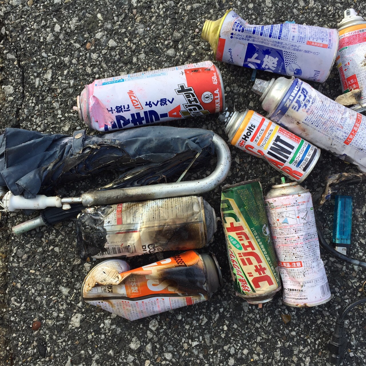 数多くの燃えたスプレー缶が写っている写真