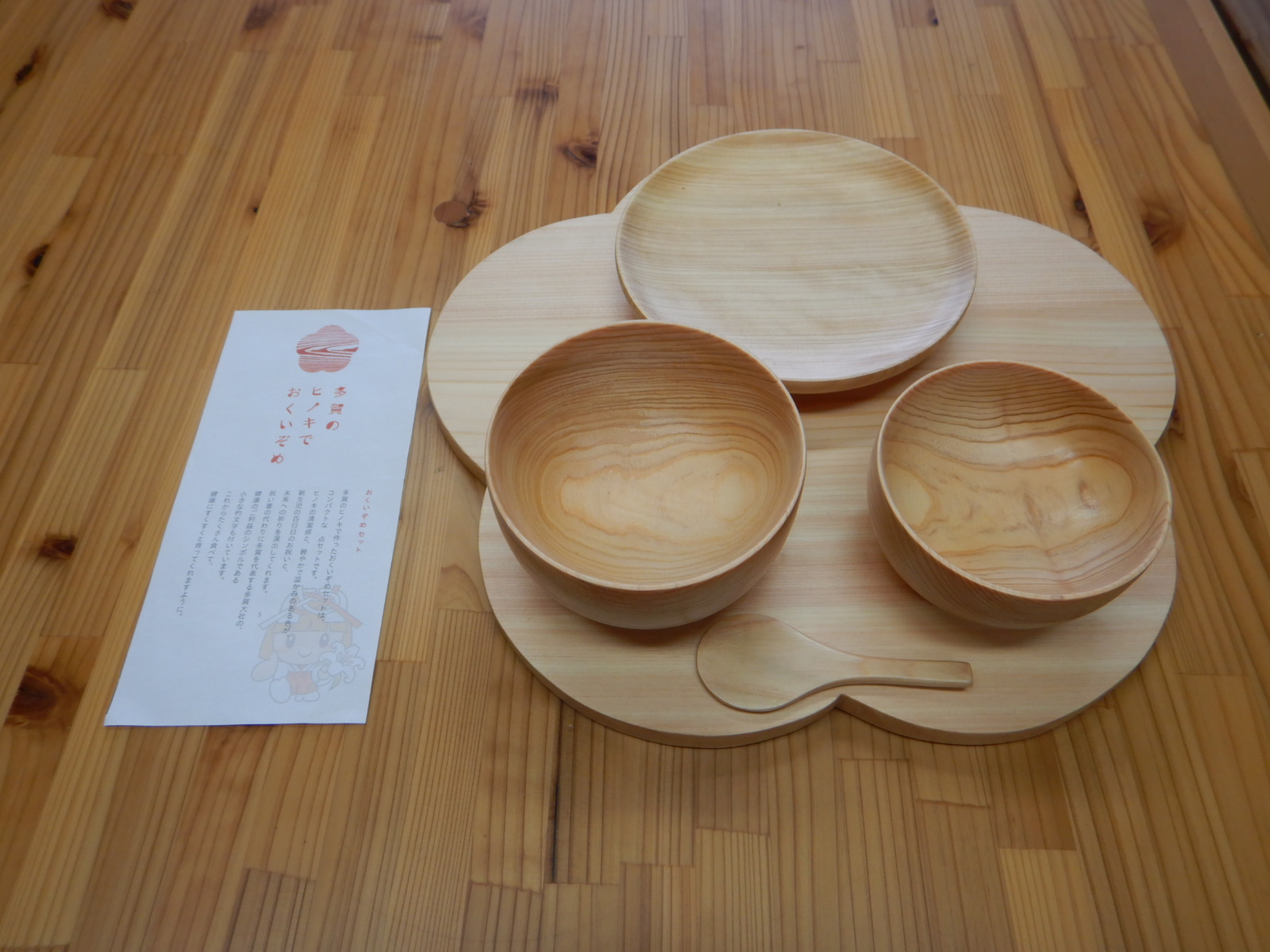 木でできた花の形をしたお盆の上に、同じく木でできた食器が四点並んでいる写真