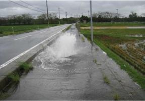曇り空の下に外で汚水があふれ出ている写真